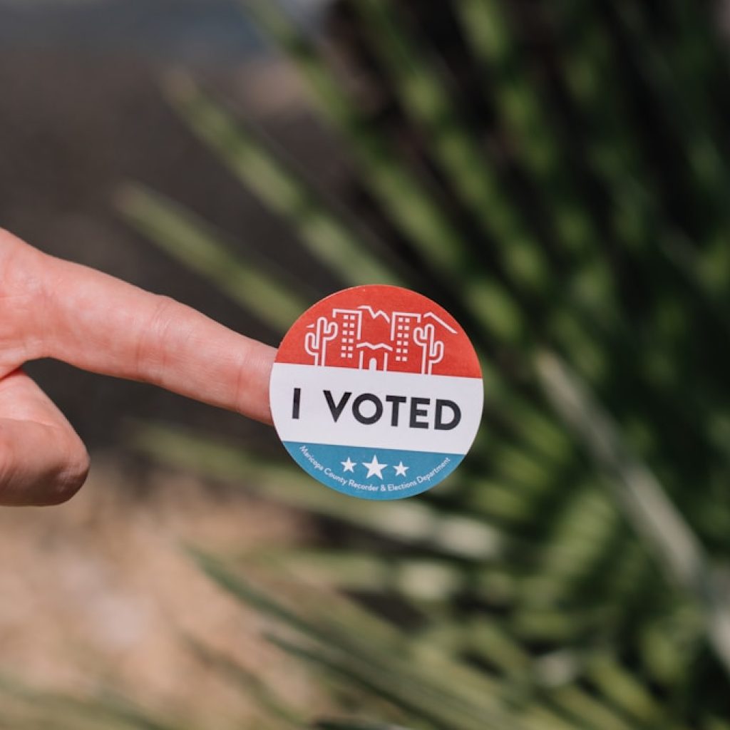 person holding red and white round pin