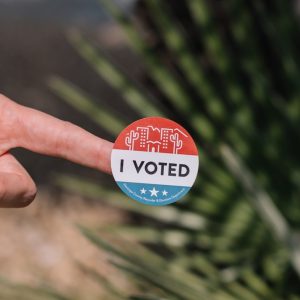 person holding red and white round pin